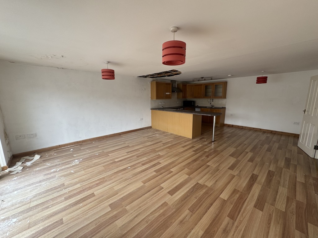 Lot: 58 - TWO-BEDROOM SECOND FLOOR FLAT FOR IMPROVEMENT - Living area and kitchen from window